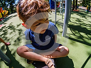 Happy boy on playground, summer childhood in park,  child active
