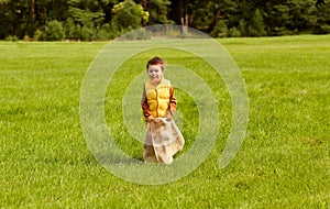 happy boy playing bag jumping game at park