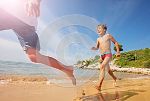 Happy boy playing beach games with friends