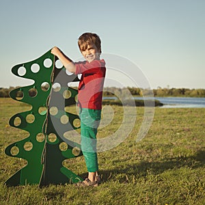 Happy boy playing with paper tree