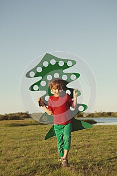 Happy boy playing with paper tree