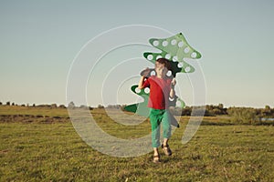 Happy boy playing with paper tree