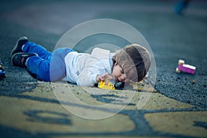 Happy boy playing in the park with dirt from a pot hole