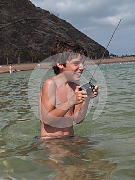 Happy boy playing with remote toy in ocean