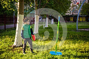 Happy boy is playing tetherball swing ball game in summer campin photo