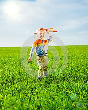 Happy boy playing with toy airplane against blue