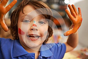 Happy boy, portrait and hands with face paint for artwork, craft or creativity at elementary school. Little male person