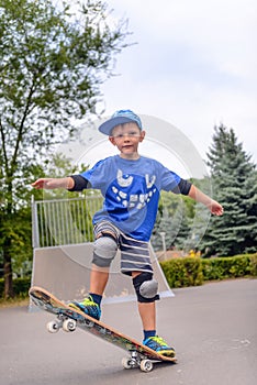 Happy boy practicing balancing on a skateboard
