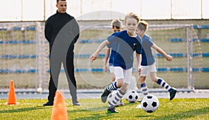 Happy boy practicing soccer on the pitch