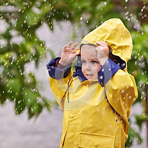 Happy, boy and rain jacket in winter with thinking for carefree, childhood and enjoyment in Germany. Kid, smile and