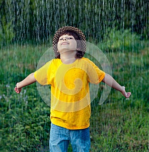 happy boy in rain summer outdoors