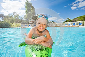 Happy boy relaxing on inflatable toy in pool