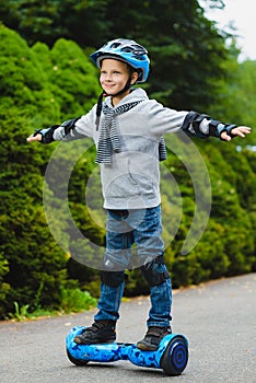 Happy boy riding on hoverboard or gyroscooter outdoor