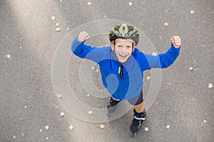 Happy boy on roller skates showing hands up