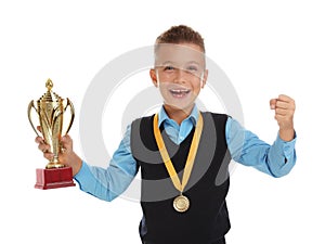 Happy boy in school uniform with golden winning cup and medal on white