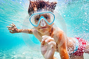 Happy boy in scuba mask swimming underwater