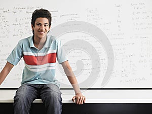 Happy Boy Sitting In Front Of Whiteboard