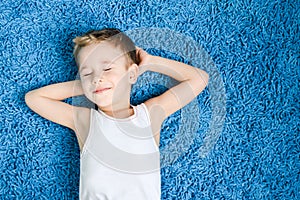 Contento un bambino sul pavimento soggiorno sul occhi chiuso 