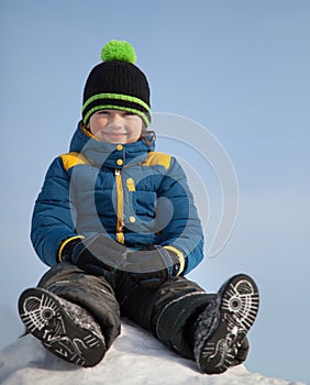 Happy boy in snow play and smile sunny day outdoors