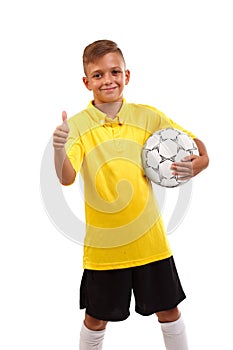 A happy boy with a soccer ball and in a football uniform isolated on a white background. The winner took the first place