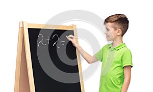 Happy boy solving math on school blackboard