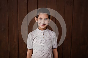 Happy boy in spectacles and polo shirt.  over brown background. Schoolboy. Teenager.