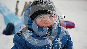 Happy boy stands and smiles in Sunny winter day in park