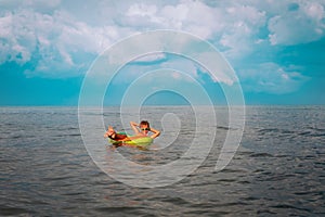 Happy boy swimming at tropical beach, child relax at sea