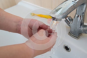 Happy boy taking bath in kitchen sink. Child playing with foam and soap bubbles in sunny bathroom with window. Little baby bathing