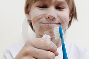 Happy boy taking toothpaste and preparing to brush his teeth with toothbrush