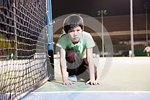 Happy boy in tennis court during his practise sport time