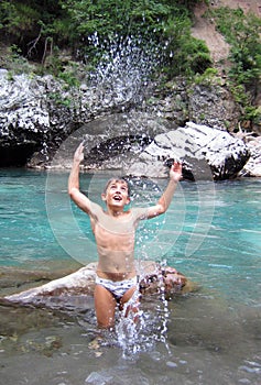 Happy boy throwing water