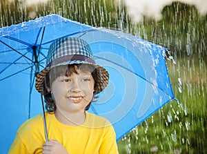 Happy boy with umbrella outdoors, child with an umbrella walks i