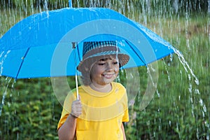Happy boy with umbrella outdoors, child with an umbrella walks i