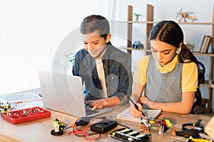 happy boy using laptop while girl