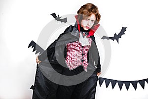 Happy boy in a vampire costume having fun photo