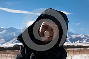 Happy boy walking in sunny mountains children`s clothing for the mountains close smiling portrait