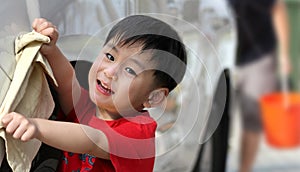 Happy boy washing car