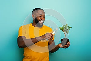 Happy boy watering a small tree ready to be planted. Concept of forestation