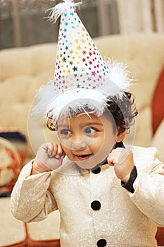 Happy boy wearing birthday hat and celebrating his birthday.