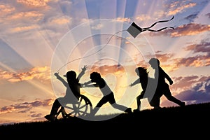 Happy boy in wheelchair playing with children and kite photo