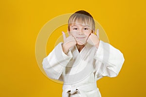 Happy boy in white kimono practices judo. Spirit of martial arts. Martial arts concept