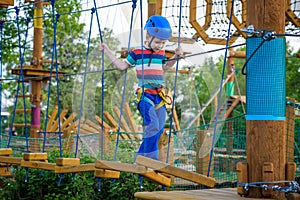 Happy boy on the zip line. proud of his courage the child in the high wire park