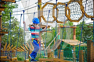 Happy boy on the zip line. proud of his courage the child in the high wire park