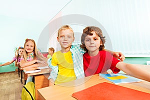 Happy boys cuddle and sit together in school photo