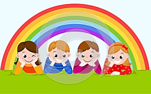 Happy boys and girls lying on a green grass with rainbow