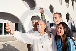 Happy boys and girls taking smiling selfie. Group of people together having fun at campus university.