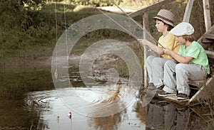 Happy boys go fishing on the river, Two children of the fisher with a fishing rod on the shore of lake, retro edit