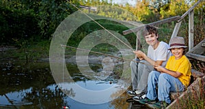 Happy boys go fishing on the river, Two children of the fisherman with a fishing rod on the shore of lake