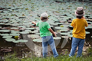 Happy boys go fishing on the river, Two children of the fisherman with a fishing rod on the shore of lake